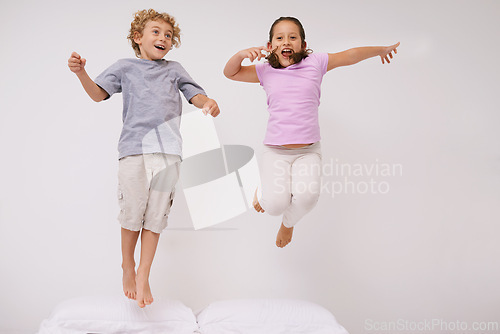 Image of Jumping, bed and kids with fun, energy and morning in a bedroom with game and sibling. Youth, hop and home with a excited children on a duvet in air with crazy play and leap in house with friends