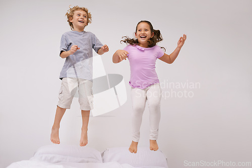 Image of Jumping, bed and kids with happy, funny and morning in a bedroom with game and sibling. Youth, hop and home with excited children in air with crazy, play and laugh with energy in house with family