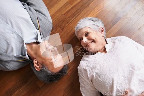 Image of Smile, senior or happy couple on floor to relax in home living room for bonding or support in retirement. Above, old people or man lying down by an elderly woman for trust, peace or care in marriage