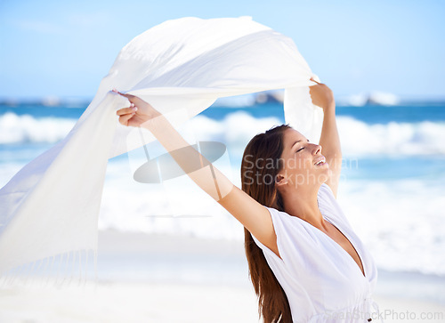 Image of Sea, happy woman and fabric in wind at beach outdoor for summer, vacation and travel on holiday. Ocean, smile and person fly with silk sarong in the air for adventure, freedom or calm breeze by water