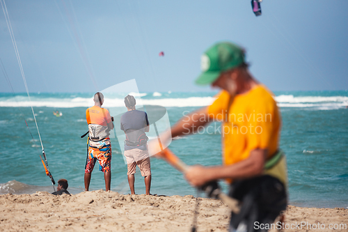 Image of Active sporty people enjoying kitesurfing holidays and activities on perfect sunny day on Cabarete tropical sandy beach in Dominican Republic.