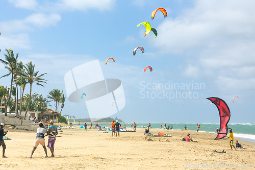 Image of Crowd of active sporty people enjoying kitesurfing holidays and activities on perfect sunny day on Cabarete tropical sandy beach in Dominican Republic.