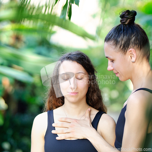 Image of Yoga concept, meditation and sound therapy. Beautiful young girl at yoga session with her yoga and meditation teacher at tropical yoga retrear