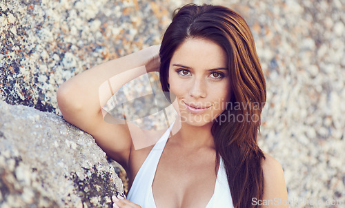 Image of Woman, portrait and bikini with confidence against rock on beach for summer vacation in the Maldives. Female person, swimwear and smile outdoors on holiday, sexy and leaning on boulder with closeup