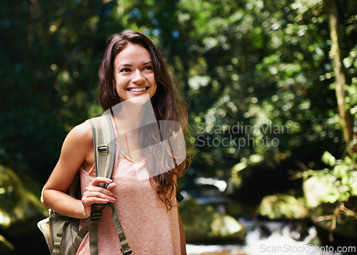 Image of Nature, happy and woman hiking with backpack for outdoor adventure trail on vacation. Smile, travel and female person with bag for trekking in forest, field or woods on holiday or weekend trip.