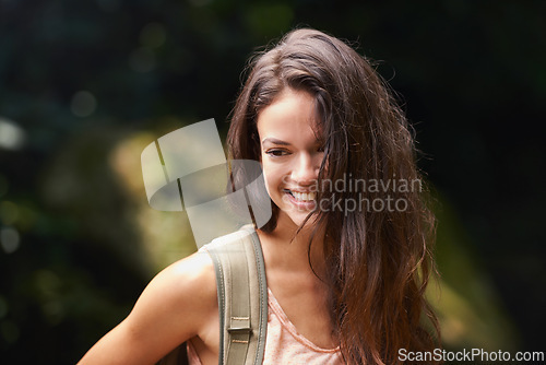 Image of Hiking, backpack or happy woman in nature, woods or wilderness for trekking or outdoor adventure with bag. Smile, relax or hiker walking in natural park or forest for exercise or wellness on holiday