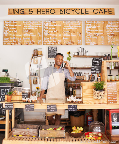 Image of Portrait, smile and phone call with black man in cafe for communication, networking or service. Coffee shop, restaurant and small business with happy young store owner or vendor working in bakery