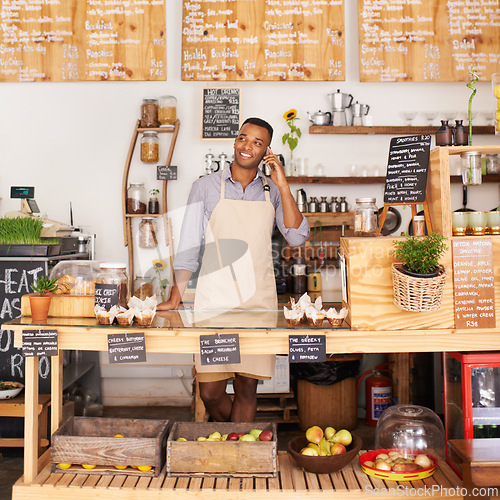 Image of Thinking, smile and phone call with black man in coffee shop for communication, networking or service. Cafe, restaurant and small business with happy young store owner or vendor working in bakery