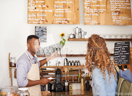 Image of Woman, coffee shop and waiter with pointing at menu for customer, purchase and decision in cafe. Barista, small business and lady in restaurant with help, shopping and choice for lunch order