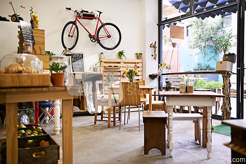 Image of Interior, bike on wall of empty coffee shop with tables and chairs for retail, service or hospitality. Space, small business or startup restaurant with cafeteria seating for bistro consumerism