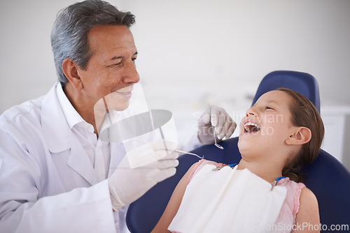 Image of Girl, child and dentist with tools for healthcare, gum disease and oral hygiene with mouth inspection. Medical, orthodontics and consultation for teeth health, cleaning and wellness with excavator