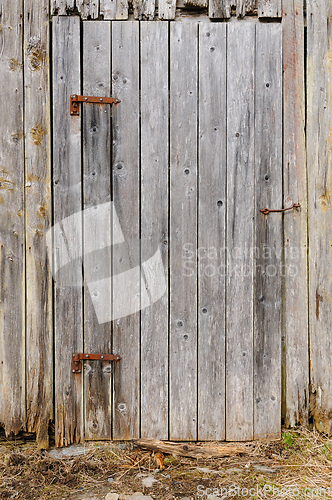 Image of Weathered wooden door on an old rustic barn during spring