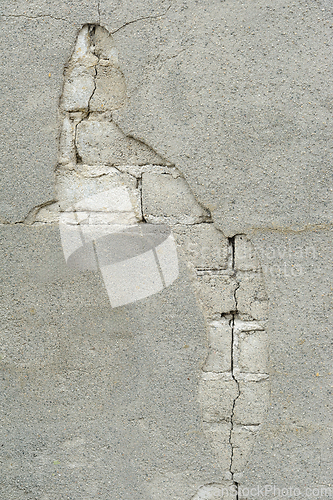 Image of Close-up view of a wall exhibiting cracking plaster and exposed 