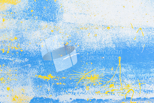 Image of Abstract blue and yellow paint splatter on a white background