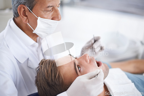 Image of Dental care, man and dentist with tools for healthcare, gum disease or oral hygiene with mouth inspection. Medical, orthodontics and consultation for teeth health, cleaning or wellness with excavator