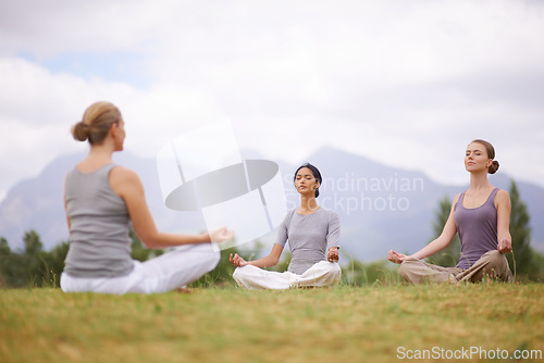 Image of Lotus, instructor and meditation outdoor for yoga, healthy body and mindfulness exercise to relax. Peace, group and calm women in padmasana in nature for balance, spirituality or breathing together