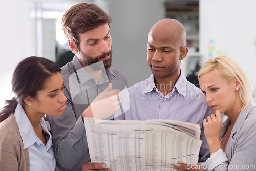 Image of Business people, newspaper and thinking in team building for information, crossword game or search at office. Group of employees with document or paperwork in planning or problem solving at workplace
