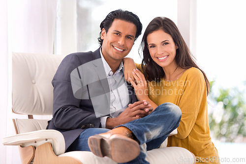 Image of Smile, love and couple on chair in living room at home with comfortable romance and care. Happy, marriage and portrait of young man and woman sitting on sofa together in lounge at modern house.