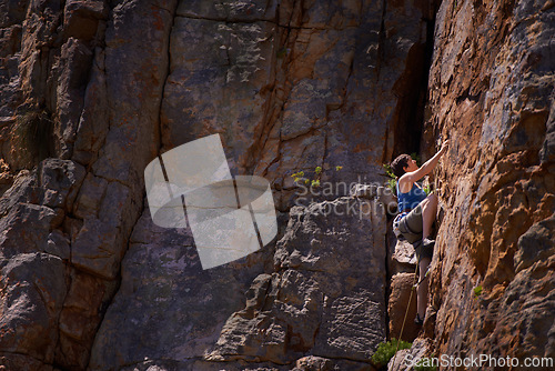 Image of Woman, mountain climbing and outdoors for adventure, fitness and exercise in the sun for extreme sports. Female person, rock workout and nature for wellness, risk and fearless activity for strength