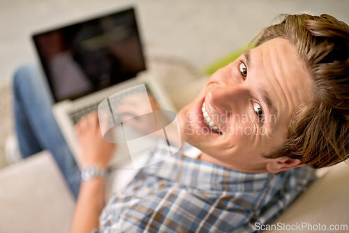 Image of Man, portrait and laptop on sofa for online as freelance journalist for report research, connectivity or networking. Male person, above and internet for remote work in London, communication or web