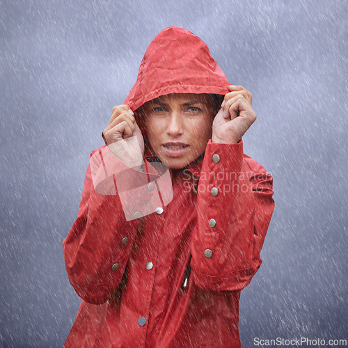 Image of Woman, hood and portrait with rain, coat and clouds with protection in nature. Person, face and storm with cloudy, winter and waterproof hat for safety and confidence with adventure or vacation