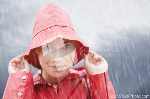 Image of Woman, smile and portrait with rain, coat and clouds with happiness in nature. Person, face and storm with cloudy, winter and waterproof hat for protection and confidence with safety or adventure