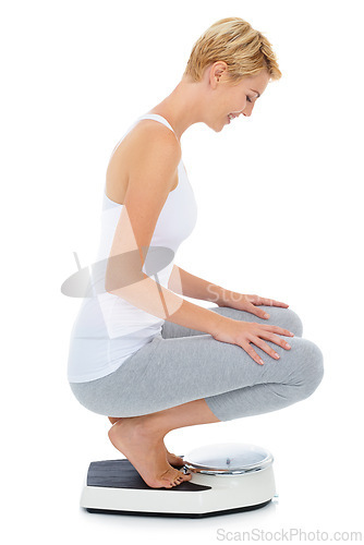 Image of Woman, happy and scale in studio for weight loss, healthcare and wellness for vitality. Female person, diet and check calories for slim body for self care, achievement and sit with white background