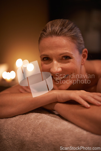 Image of Female person, smile and spa for wellness, relax and self care and massage on table being happy. Woman, body treatment and portrait to destress, peace and detox for calm and holistic relaxation