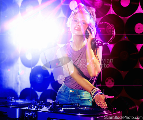 Image of Portrait, woman dj and headphones for retro, nightclub and party with neon lights and lens flare. Happy gen z person, listen and mixing tracks and vinyl at rave or techno music event in Berlin disco