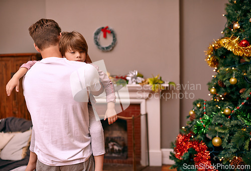 Image of Father, son and embrace with comfort on christmas for celebration, sleeping and love in the morning. Family, man and child with hug, relax and enjoying holiday season in living room or lounge of home