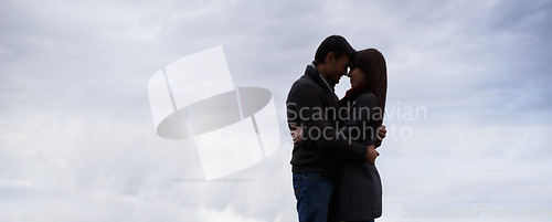 Image of Couple, sky and hug together with love for romance, commitment and care for feeling safe. Man, woman and relationship with mockup, space and banner outdoors on honeymoon with spouse comfort and trust