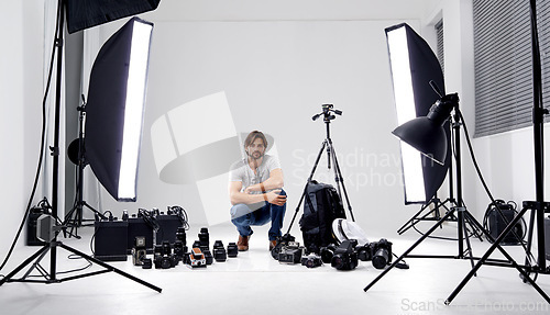 Image of Photographer, portrait or lighting with equipment in studio for career, behind the scenes or camera. Photography, guy and confidence with electronics, flash or shooting gear for photoshoot or passion