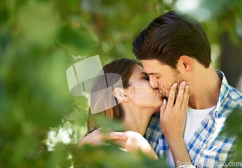 Image of Couple, garden and kiss with love for date, bonding and romance with embrace in nature park. Man, woman and happy relationship with affection in summer for vacation, weekend or travel together