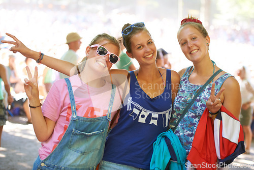 Image of Portrait, friends and peace sign while bonding with smiles at outdoor music festival in Germany. Confident, relaxed and female students with happiness at outdoor event on summer or Spring afternoon