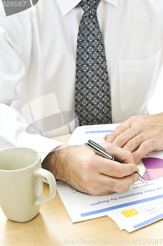 Image of Office worker writing on reports