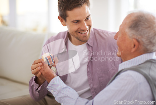 Image of Senior, man and son or medal on sofa with war badge, pride and honor for military hero in living room of home. Elderly, veteran and retired soldier with medallion for service in army with happiness