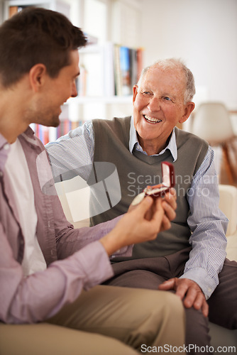 Image of Dad, adult son and medal for present support and congratulations with celebration and bonding at home. Men in living room, family time with reward or award as gift for happiness and gratitude