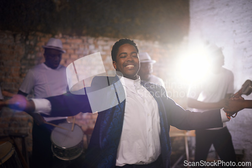 Image of Dancing, happy man and musician with band at stage for music and celebration event. Performance, concert and smile of African person with group at party with energy, artist and drums with lens flare