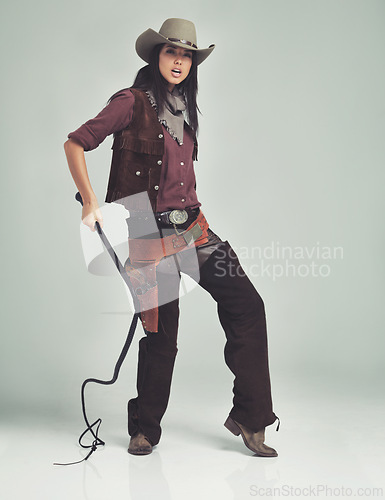 Image of Woman, cowgirl and portrait in studio for outfit costume with confidence on white background, weapon or outlaw. Female person, whip and hat with mockup space in Texas for dress up, old west or rodeo
