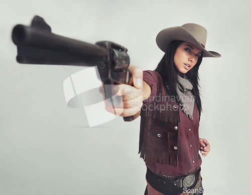 Image of Cowgirl, portrait and gun pointing or western costume with confidence on white background, weapon or mockup space. Female person, face and revolver in studio or old west Texas, accessories or bandit