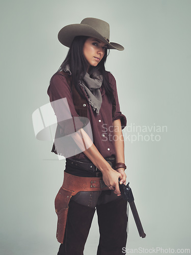 Image of Woman, fashion and cowboy clothes with gun in studio, western character and costume isolated on white background. Wild west style, pistol for outlaw cosplay and vintage apparel in a portrait