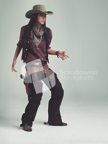Image of Woman, fashion and cowboy clothes with confidence in studio, western character and costume on white background. Wild west style, outlaw cosplay and vintage apparel with mockup space and aesthetic