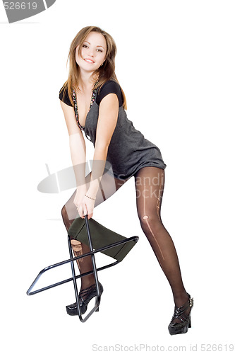 Image of Young woman in the torn stockings with a chair