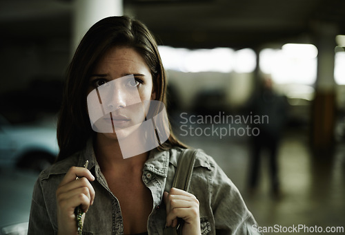 Image of Woman, suspicious and parking lot with anxiety, worried and stressed for safety and concern. Female person, blur background and scared with backpack, terror and portrait for scary place and in fear