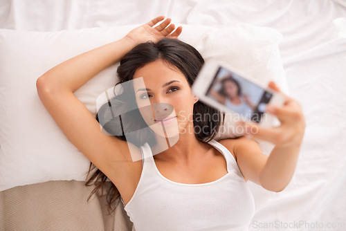 Image of Woman, selfie and above bed to relax on vacation, hotel or photography for web blog in morning. Girl, person and influencer for profile picture, home and live streaming in bedroom for social network