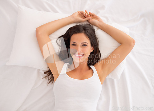 Image of Top view, woman and portrait to relax in bed, smile and calm on morning in home. Happy female person, wake up and ready for start of weekend in apartment, comfortable and peace or lazy for wellness