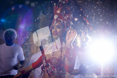 Image of Samba, woman and dancer with band at festival in rio de janeiro for brazilian carnival with feather costume or smile. Person, face or night with dancing, fashion or light for culture or outdoor event