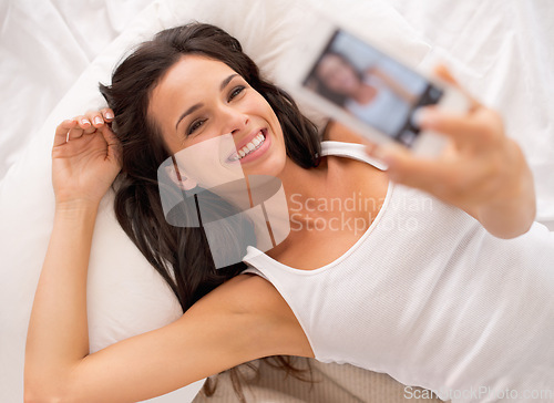 Image of Woman, selfie and above in bedroom with smile on vacation, hotel or relax for photography on web blog. Girl, person and influencer for profile picture, home and live streaming in bed on social media