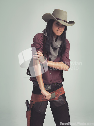 Image of Western woman, cowgirl and strong in portrait, muscle and costume for tough with confidence. Female person, cowboy hat and clothes from Texas, white background and dress up for strength or proud