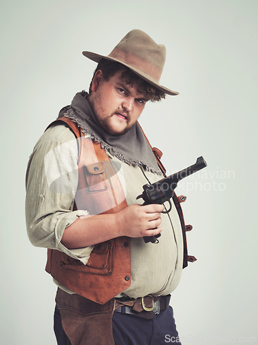 Image of Portrait, man and cowboy with a gun, confidence and person on a white studio background. Face, model and guy with a pistol and firearm with danger and warning with Halloween costume, proud and Texas